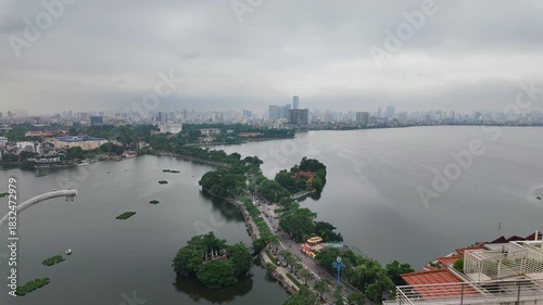Timelapse of Hanoi city, Vietnam with road crossing the island lake with green tree lined street, temple located between small oasis.
