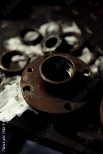 Replacing a wheel bearing in a classic car. Old vehicle restoration concept. Worn wheel bearing on a dirty, oily napkin. Metal textured background.