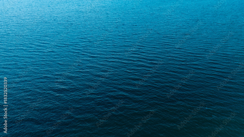 Fototapeta premium Top view of deep blue sea water surface with small ripples, aerial drone shot of turquoise ocean texture at island , abstract nature background 