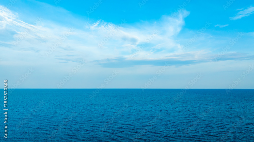 Obraz premium Nature of the ocean and blue sky Summer with sunshine, sandy beaches, clear blue waters sparkling against the blue sky. on an island with good ecology and environment Background for summer vacation