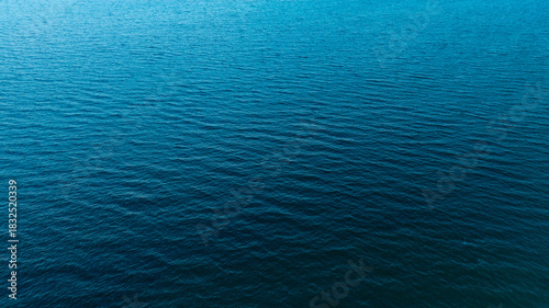 Top view of deep blue sea water surface with small ripples, aerial drone shot of turquoise ocean texture at island , abstract nature background	