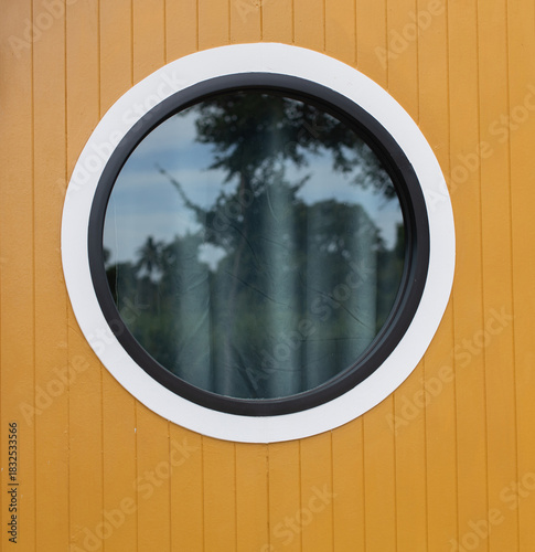 Round glass window with grey curtains