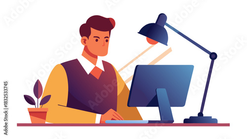 Focused male professional in graduation gown working on laptop at desk with study lamp and flowers