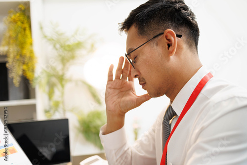 Two men are sitting at a desk, one of them is holding a piece of paper. They are having a conversation, and it seems like they are discussing something important. The atmosphere is tense
