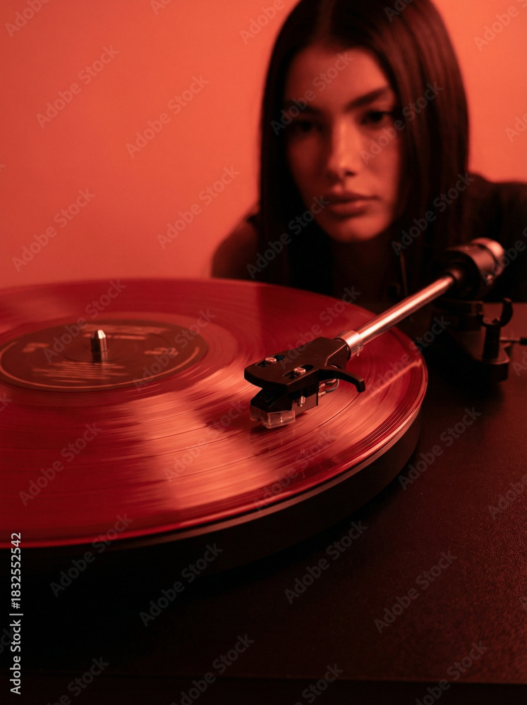 Obraz premium Red Vinyl Spinning on Turntable with Retro Mood Lighting and Soft Background Blur
