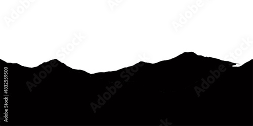 Sunset landscape silhouette of mountain and hills against the orange and blue sky at dusk with clouds and mist on the horizon