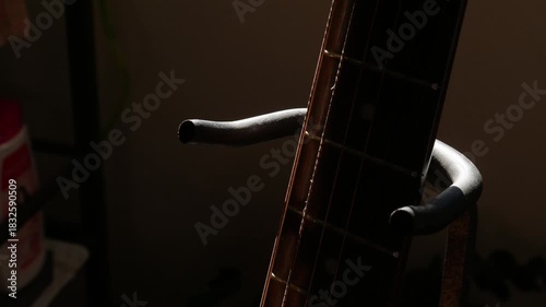 Guitar Stand on Fretboard: Metal Support Holder on Acoustic Guitar Neck with Strings and Fret Markers Detail