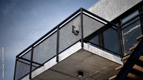 Minimal geometric mansion balcony with black steel mesh railing and concrete slab mid-day overhead sunlight with hard edge