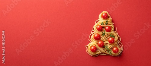 Spaghetti pasta forming a christmas tree on red background, copy space