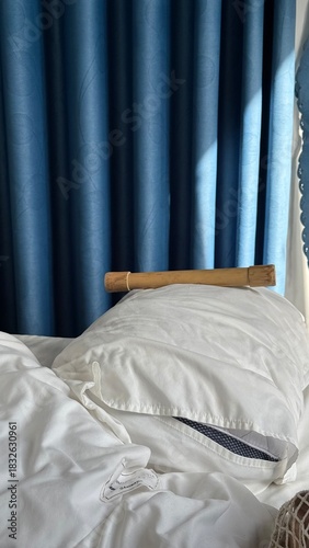 Serene Bedroom View with Bamboo on Pillow and Sunny Blue Drapes