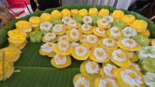 Exquisite Thai Dessert Display: A stunning array of meticulously crafted traditional Thai desserts, arranged on fresh banana leaves, each treat a testament to culinary artistry and cultural heritage.