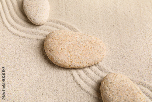 Photography Composition with spa stones and lines on sand as background, closeup