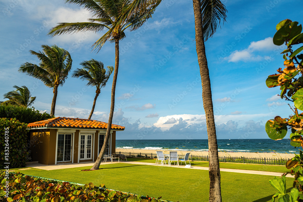 Obraz premium Tropical beach house with ocean view and palm trees. Summer vacation by the sea. Luxury tropical home with private beach access. Resort paradise for relaxation and travel. Summer holiday.