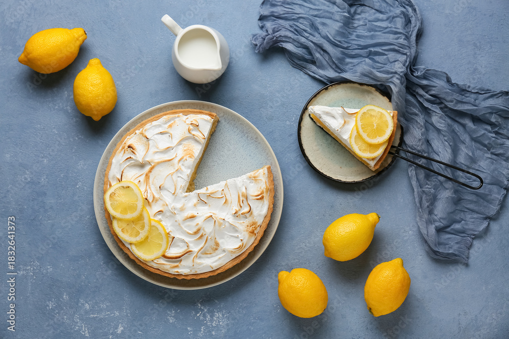 Obraz premium Plate with tasty lemon pie and jug of milk on blue grunge background