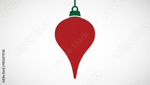 Simple red teardrop shaped christmas ornament with a green cap hangs from a string against a clean white background minimalist holiday decoration