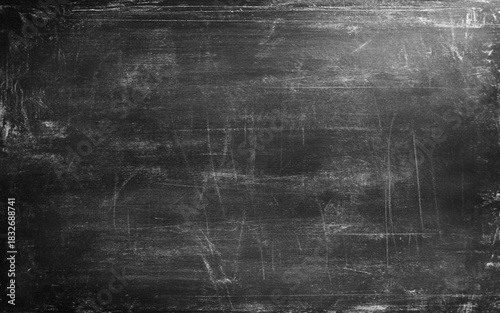 Blackboard texture background with dark wall backdrop. Rough grainy stone surface in black and dark gray tones. Vintage grunge wall with old textured design