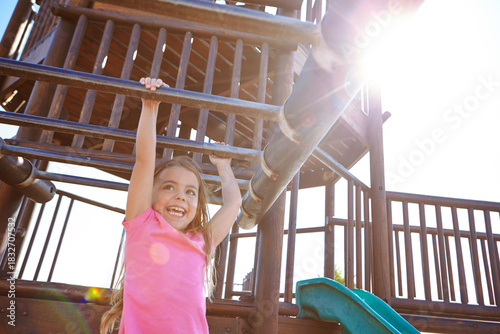 Photography Happy girl, playing and hanging with monkey bars for playful childhood or fun outdoor summer