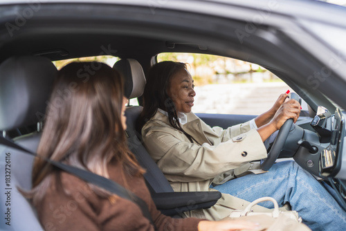 Two women sharing a conversation while driving a car. Enjoying carpooling, friendship, and travel on a road trip journey