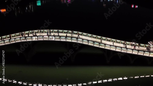 A Brilliantly Lit White Arch Bridge Reflecting on a Serene Lake at Night, China