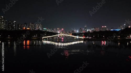 A Brilliantly Lit White Arch Bridge Reflecting on a Serene Lake at Night, China