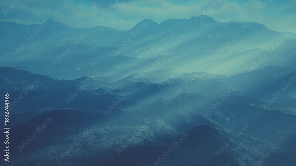 Fototapeta premium In the early morning, layers of mountains emerge from the mist, bathed in soft blue hues. Gentle rays of light pierce through the clouds, adding a dreamy quality to the serene landscape.