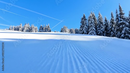 Winter wonderland ski resort scene with freshly groomed snow and sunny blue sky view