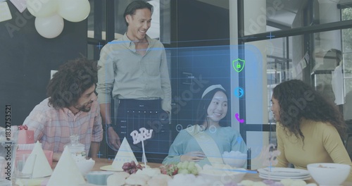 Laughing team leaning toward office table, celebrating guest wearing sash, headband with hologram