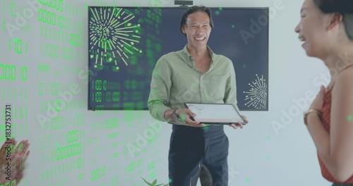 Presenting man in light green shirt with tablet at office, screen with green fireworks overlay
