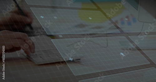 Typing left-hand on mini-keyboard at office wood desk with cuff monitor glasses UI grid, copy space