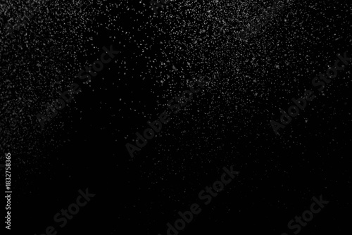 The falling white snow on a black background