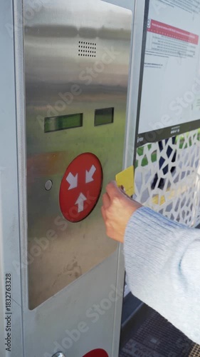 Woman's hand validating public transport ticket card on a public transport machine