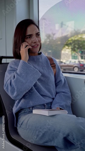 Smiling woman talking on her smartphone while traveling by public transport