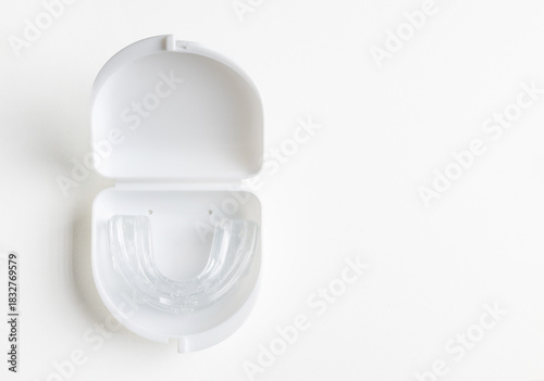 Anti snoring mouth guard made of reusable silicone shown on a white table or blue backdrop. The device is displayed from a side view or top view, clean and minimal, medical product style.