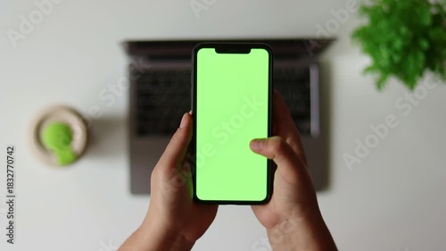 Woman sit use digital tech cell phone, green screen mock up. Hand scroll iphone web site, swipe like photos. Girl hold mobile closeup. Chroma key page. Cozy office background. Online app copy space.
