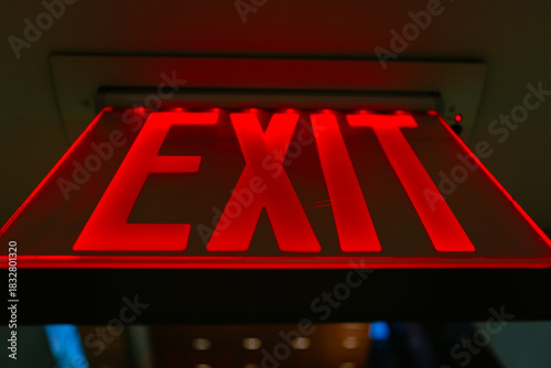 Illuminated Exit Sign Glowing Red in Dark Corridor 