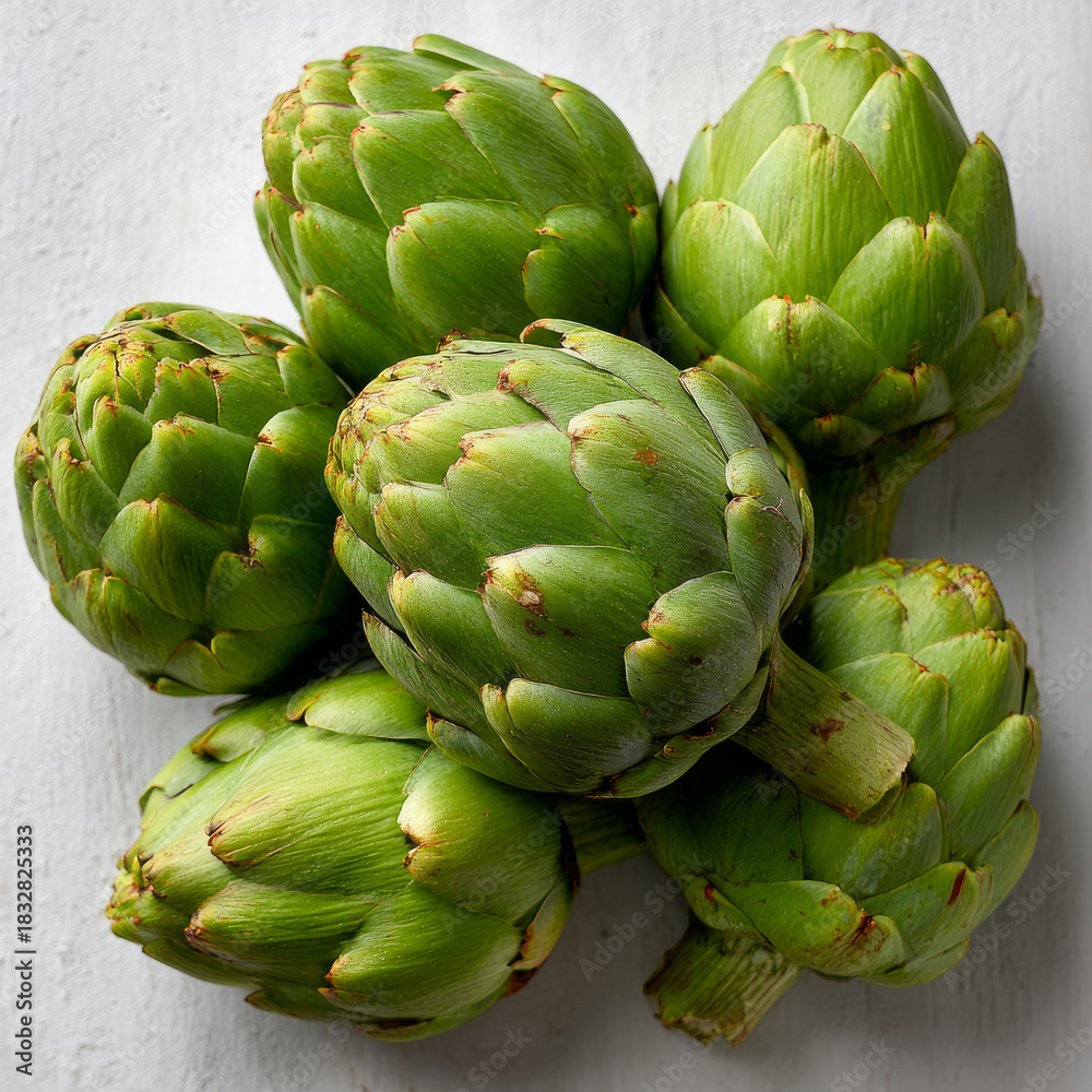 Obraz premium Fresh green artichokes arranged on a light background.