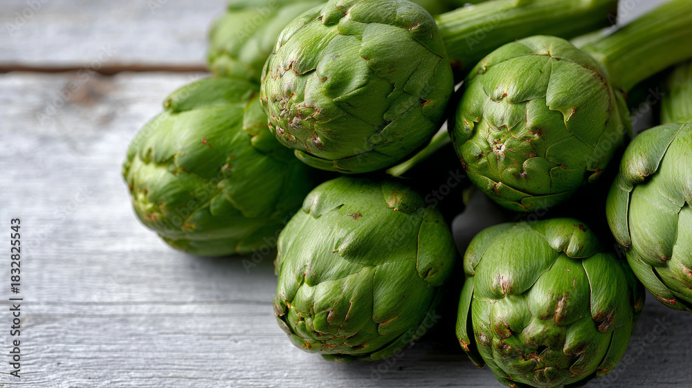 Fototapeta premium Fresh artichokes on a rustic wooden background.