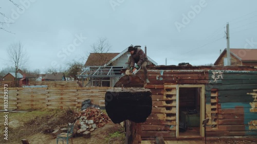 Sawing a house, sawing a wooden house, sawing logs with an electric saw, dismantling a house