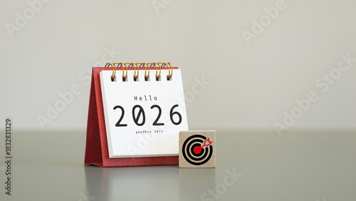 white desk calendar year 2026 with target icon on wooden cubes with copy space, symbolizing goals and planning, business strategy for new year 2026