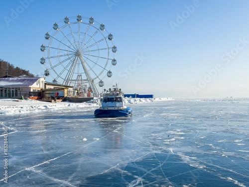 The hovercraft on frozen icy surface of the Baikal lake . Clear winter weather