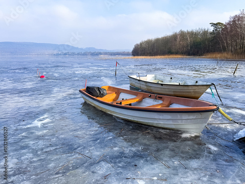 A small boats are trapped in the ice of lake in Sweden during winter.