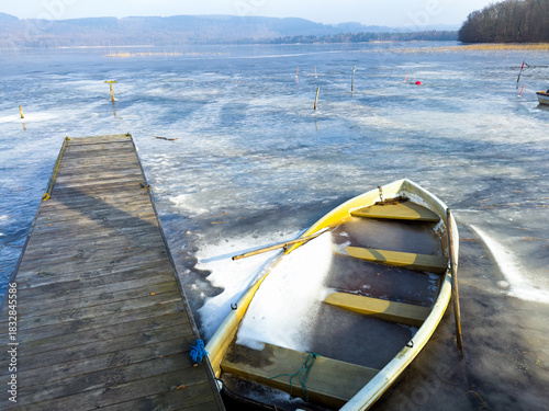 A small boat is trapped in the ice of lake in Sweden during winter.