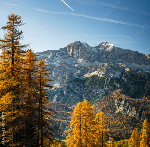 Autumn in the Dolomites. Explosion of colors towards sunset. Enrosadira and larch forests