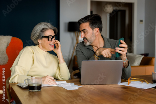 Mature couple discussing finance, making plans at home