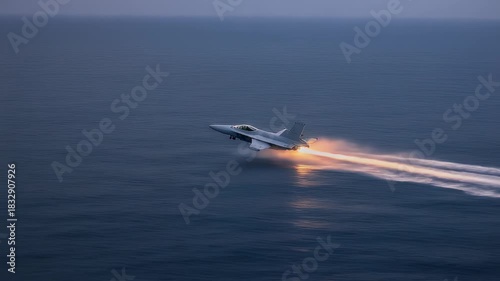 Jet fighter flying over the ocean at high speed with afterburners on.