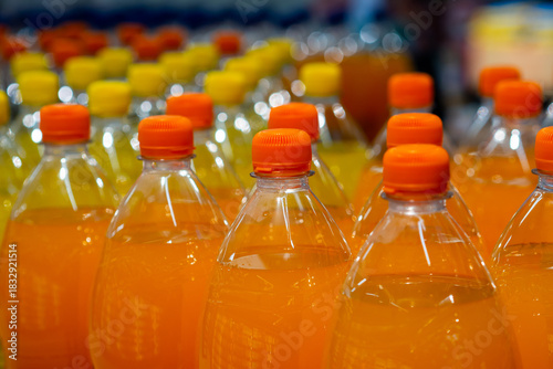 Rows of Refreshing Orange Bottled Drinks for Sale