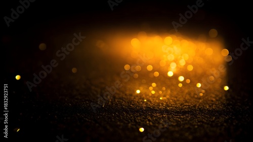 Blurred gold glitter on dark background