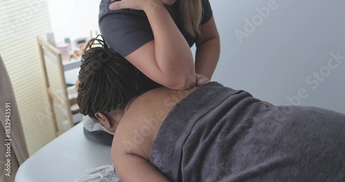 Female chiropractor therapist doing back massage to a senior woman patient inside her studio - Healthcare, wellness and healthy lifestyle concept