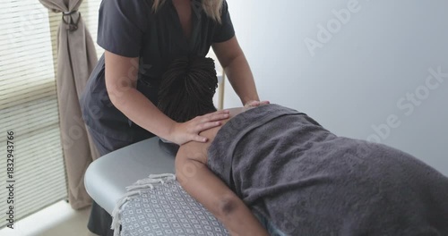 Female chiropractor therapist doing back massage to a senior woman patient inside her studio - Healthcare, wellness and healthy lifestyle concept