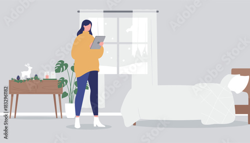 Woman enjoying a peaceful winter morning at home using a digital tablet